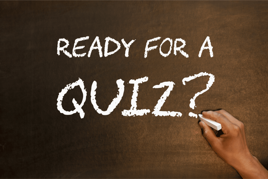 A hand holding chalk writes "READY FOR A SUITABILITY QUIZ?" on a dark chalkboard surface in white, textured letters.
